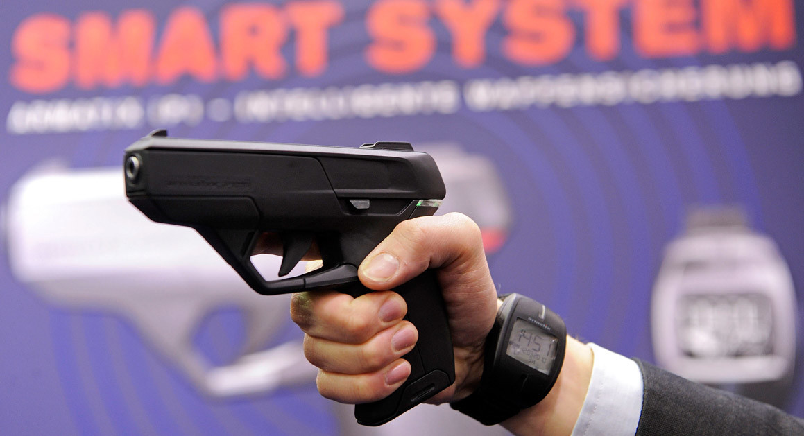 An employee of German arms manufacturer Armatix poses with the company's smart gun concept weapon at the International Weapons trade fair in Germany in 2010. | Getty 